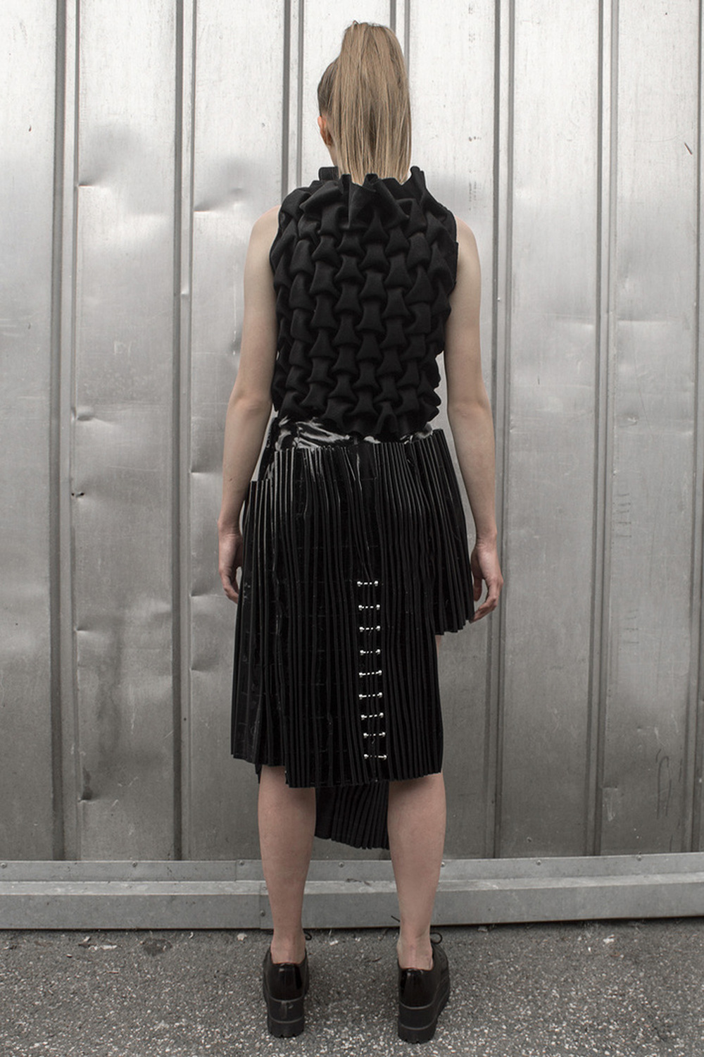 Look 6

Hand-smocked cashmere top with metal embellishments and a pleated, black vinyl skirt 